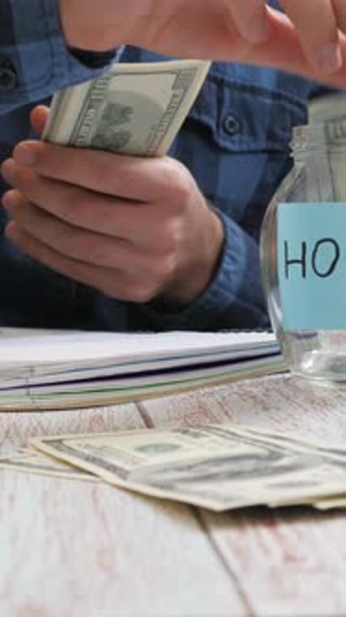 Man Counts Money and Saves for House or Taxes