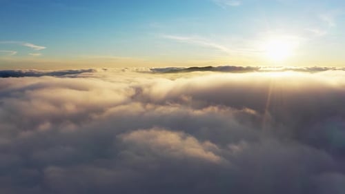 Soleil brillant au-dessus des nuages blancs duveteux au lever du soleil