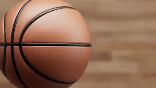Boucle rotative de basket-ball 3D réaliste sur fond de bois défocalisé