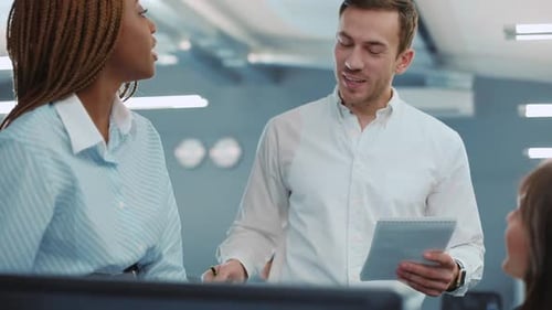 Office Colleagues Discussing Project at Computer Workstation