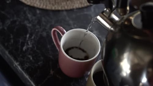 Metal Teapot Filling a Cup of Hot Water with Instant Coffee New Zealand