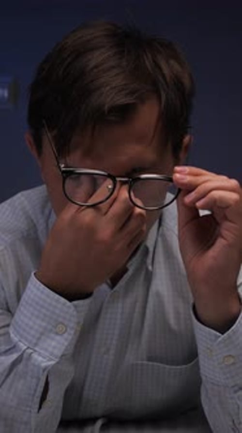 Man Rubbing His Eyes While Wearing Glasses
