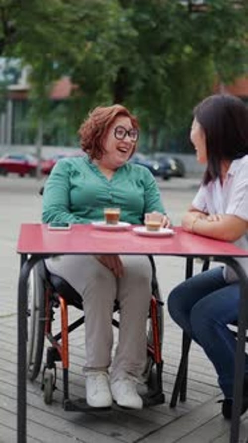 Woman in Wheelchair Enjoying Coffee with Friend