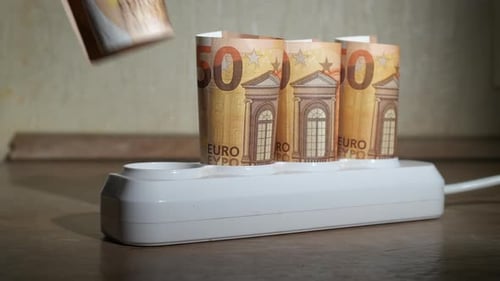 Euro Bills Inserted Into Power Strip Sockets