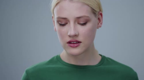 A Contemplative Young Woman Dressed in a Green Shirt Capturing Deep Reflection and Calmness