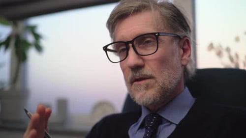 Man in Glasses Talks in Corporate Setting