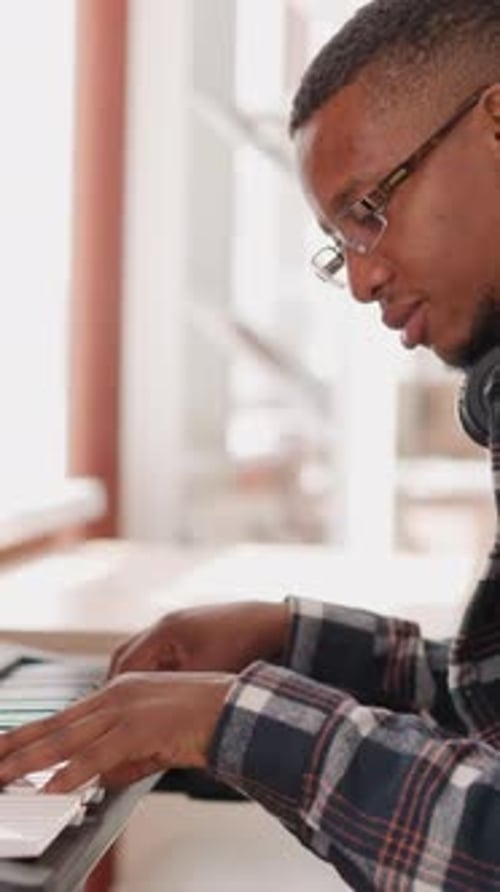 Young Man Plays Electric Piano Indoors