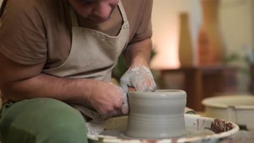 Male artisan craftsman slow motion forming clay vase sculpture on workshop pottery wheel