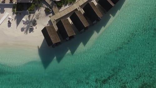 Tiro de drone, movimento circular acima do spa de vilas aquáticas em um resort nas Maldivas. Água azul e turquesa.
F