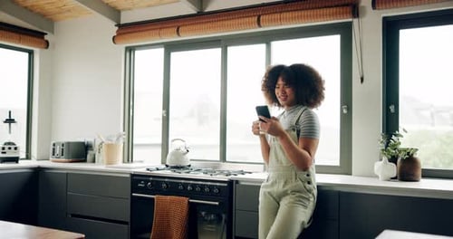 Woman Uses Smartphone in Modern Kitchen