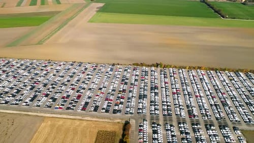 Aerial footage of finished cars ready to be shipped on huge distribution center