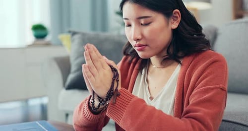 Christian woman, rosary and praying in home of spiritual faith, holy gospel and worship God