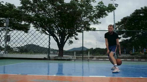 basketball player playing alone on the court in the park