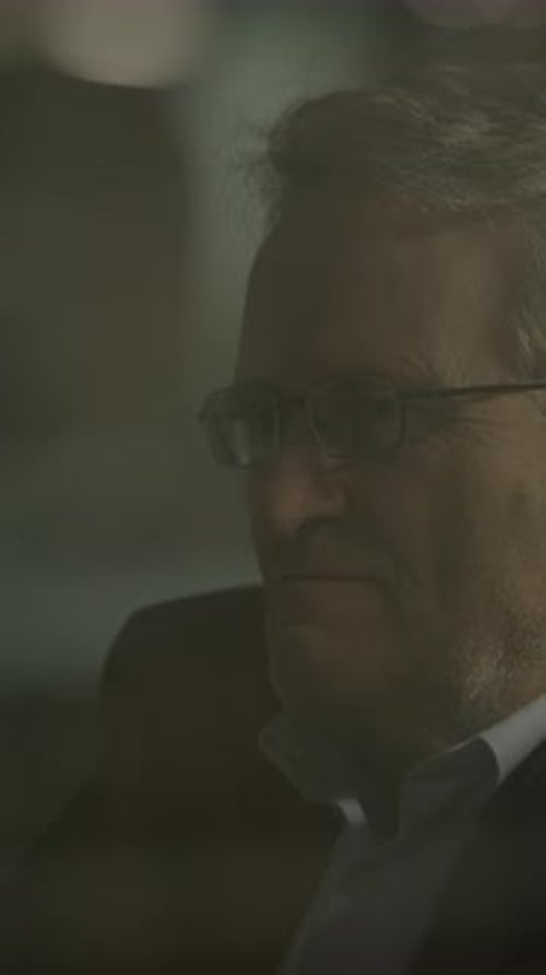 Adult in Suit Taking off Glasses at Night