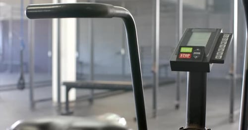 Bicicleta estática en el gimnasio con pantalla digital que muestra los botones de inicio y parada