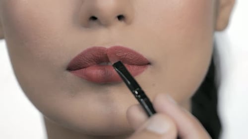 Applying Red Lipstick With Brush Close Up