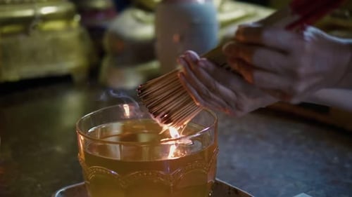 Hands Place Incense in Bowl of Oil for Worship