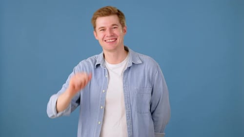 Lächelnder stilvoller Kerl macht Hallo-Geste im Studio