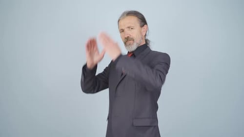 Mature Businessman Adjusting His Suit in Studio
