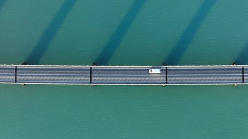 Brücke über türkisfarbenes Meerwasser, städtische Infrastrukturstraße für Autos, abstrakt, symmetrisch