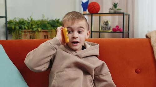 Young Boy Talking on Smartphone at Home