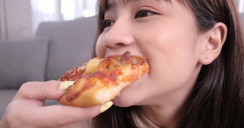 Close up asian woman takeaway eating junk food slices of pizza having snack