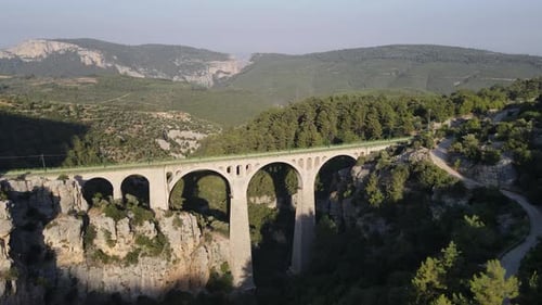 Historical stone bridge, Drone view of a historical stone bridge built over the river covered with g