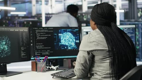 Woman Typing at Computer Analyzing Brain Scan