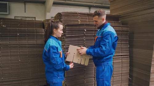 Arbeiter der Verpackungsfabrik inspizieren das Kartonlager