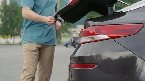 Sortir les sacs du coffre de la voiture