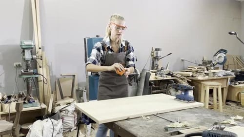 Young female carpenter working in a workshop