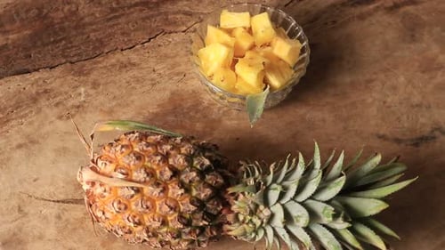 Pineapple Chunks and Whole Pineapple on Wood Surface
