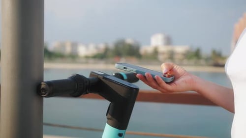 Close-up of hands with phone. Tourist taking e-scooter. Phone application for rental scooter.