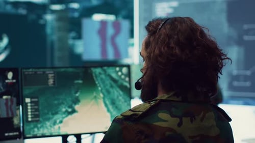 Man Monitors Data at Futuristic Command Center