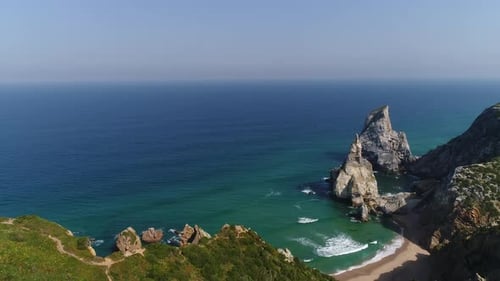 West Portugal coastline aerial flight over Ursa beach with rocks sticking out of the water