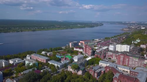 Summer time from a bird's-eye view. Clip. A big city with houses and buildings surrounded by a river