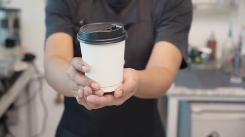 Hands Offering Coffee Cup at Cafe or Restaurant