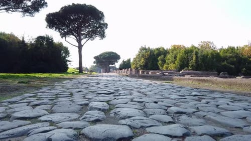 Roman road stone-paved at the entrance of Ostia Antica, a world famous archeological site.