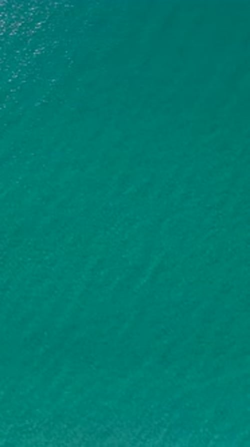 Vertical Video Stunning Ocean Texture in Calm Weather with Clear Azure Water Sparkling Under