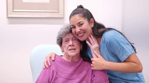 Smiling woman hugs her gray haired senior mother