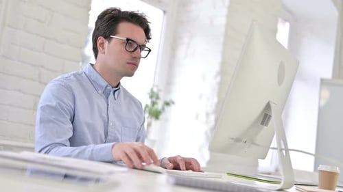 Tired Working Young Man having Headache in Modern Office