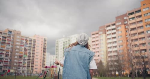 Woman Walking and Spinning in Apartment Courtyard