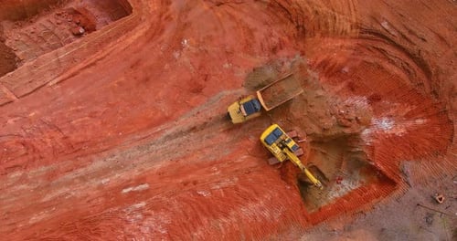 Excavator Loads Dump Truck at Construction Site