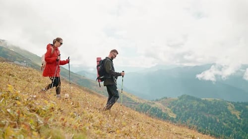 Couple Hiking Down Mountain Hillside in Nature