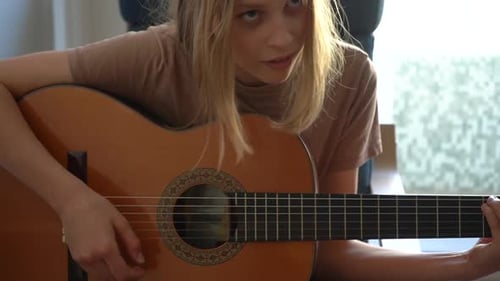 Teen Girl Plays Acoustic Guitar and Sings