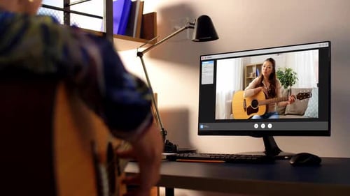 Man Takes Guitar Lesson Online With Woman