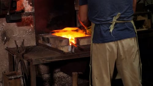 Craftsman Removing Hot Metal From Furnace