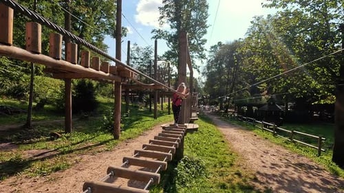 Happy Little Girl Playing in Tarzan Attraction on Playground in Amusement Park. Little Girls Enjoy P