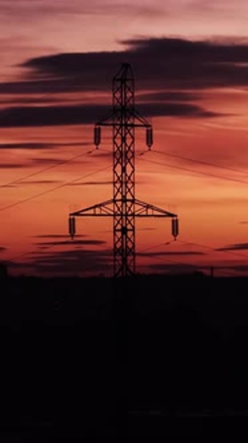 Silueta de pilón de línea eléctrica durante la puesta de sol