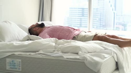 Man Jumps on Bed and Lies Down, Relaxing